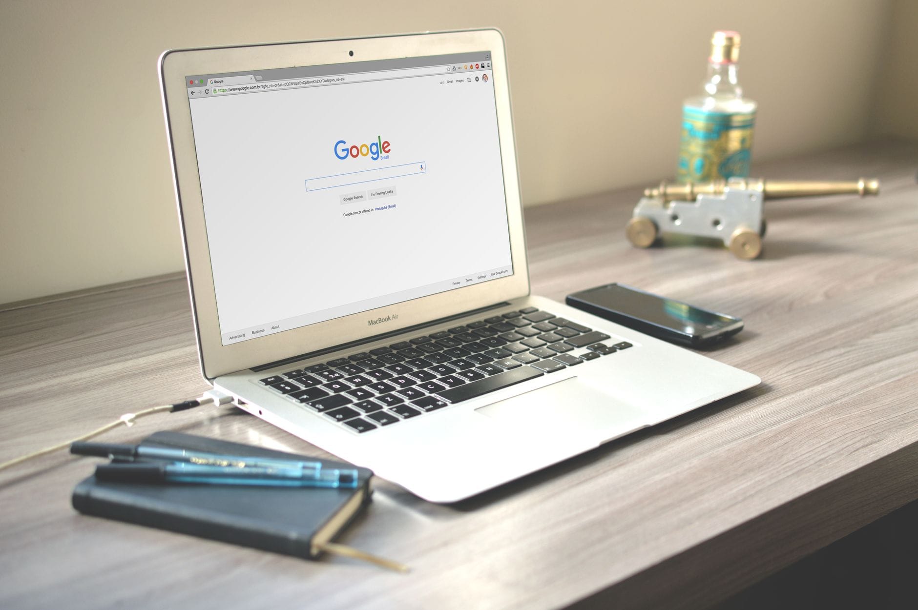Laptop z wynikami Google, telefon i notes na drewnianym biurku