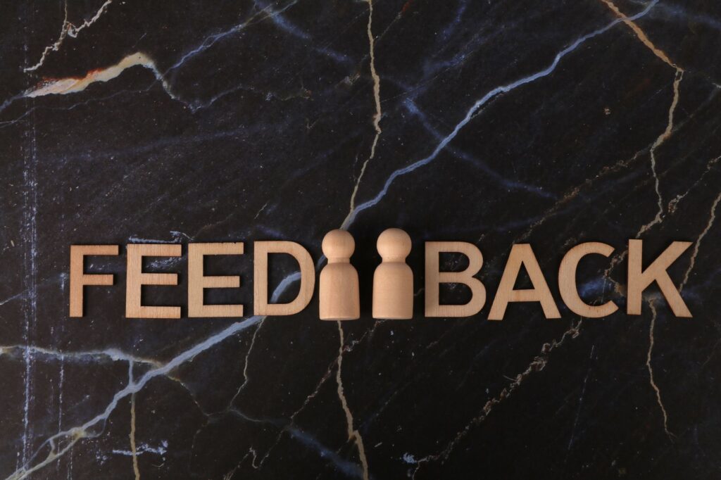 Drewniane litery układające słowo feedback na ciemnym marmurze